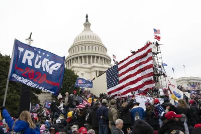 Violent insurrectionists loyal to President Donald Trump stand outside the U.S. Capitol in Washington on Jan. 6, 2021.