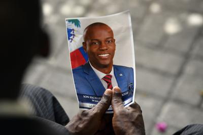 A person holds a photo of late Haitian President Jovenel Moise during his memorial ceremony at the National Pantheon Museum in Port-au-Prince, Haiti, July 20, 2021.