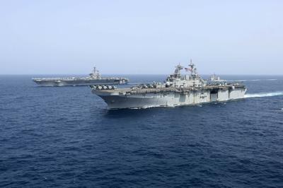 The USS Kearsarge sails in front of the USS Abraham Lincoln aircraft carrier in the Arabian Sea in 2019.