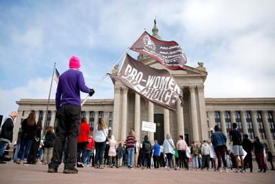 A person holds flags during the Bans Off Oklahoma rally on the steps on Oklahoma state Capitol in Oklahoma City, Tuesday, April, 5, 2022.