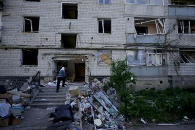 A residents enters her home building ruined by shelling in Borodyanka, Ukraine, Tuesday, May 24, 2022.