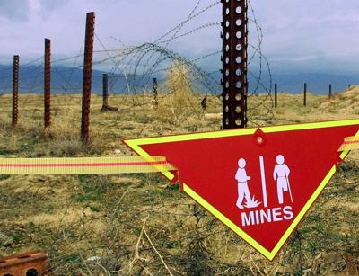 An international sign warning about mines hangs beside a minefield at Bagram Air Base.