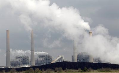 In this Wednesday, March 16, 2011 file photo, exhaust rises from smokestacks in front of piles of coal at NRG Energy's W.A. Parish Electric Generating Station in Thompsons, Texas.