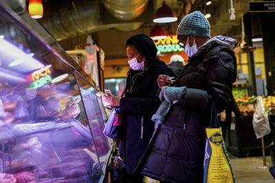 Customers wear face masks to protect against the spread of the coronavirus as they shop at the Reading Terminal Market in Philadelphia on Feb. 16.
