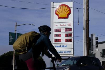 A bicyclist rides past a price board at a gas station in San Francisco, Monday, April 4, 2022.