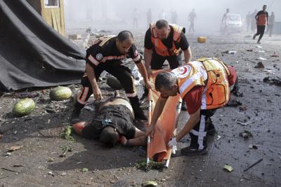 Members of Palestinian Civil Defense remove the body of someone killed in an explosion near his  house in the Gaza Strip on Aug. 7, 2022.