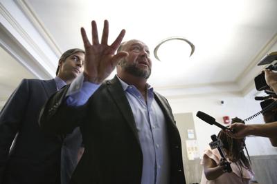 Alex Jones talks to the media during a midday break during the trial at the Travis County Courthouse in Austin, Texas, Tuesday, July 26, 2022.