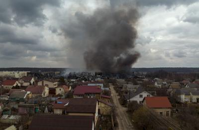 A factory and a store burn after being bombarded Sunday in Irpin, on the outskirts of Kyiv, Ukraine.