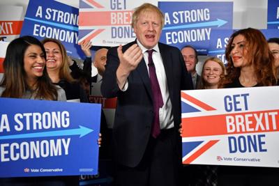Britain's Prime Minister Boris Johnson  speaks to activists and supporters as he poses for a photograph at the Conservative Campaign Headquarters Call Centre, while on the General Election trail, in central London, Sunday, Dec. 8, 2019. Britain goes to ...