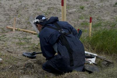 A mine detection worker with the HALO Trust de-mining NGO searches for anti-tank and anti personnel land mines in Lypivka, on the outskirts of Kyiv, Ukraine, June 14, 2022.