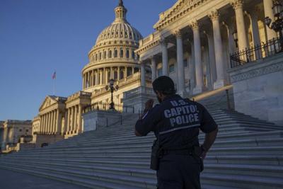 A U.S. Capitol Police officer stands at the steps of the Senate at dawn in Washington, Monday, Sept. 27, 2021. (AP Photo/J. Scott Applewhite)