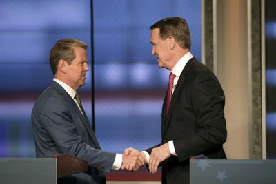 Georgia Gov. Brian Kemp, left, shakes hands with former Sen. David Perdue at a Republican gubernatorial debate on April 24, 2022, in Atlanta.