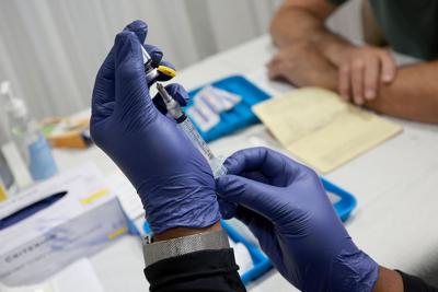 A health care worker prepares to administer a vaccine to a person for the prevention of monkeypox on July 12, 2022, in Wilton Manors, Fla.