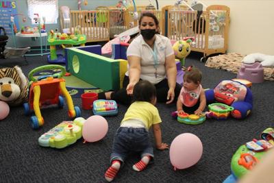 A teacher works with two infants at Cuidando Los Ninos in Albuquerque, N.M.
