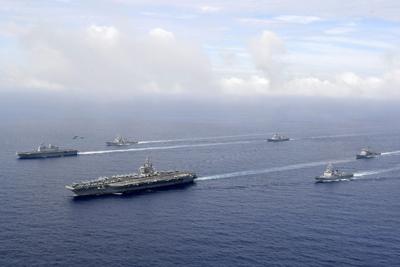 U.S. nuclear-powered aircraft carrier USS Ronald Reagan, second from left, and South Korea's landing platform helicopter  ship Marado, left, sail during a joint military exercise at an undisclosed location, June 4, 2022.