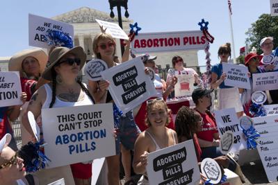 Abortion-rights activists setup an abortion pills educational booth as they protest outside the Supreme Court in Washington, Monday, July 4, 2022.