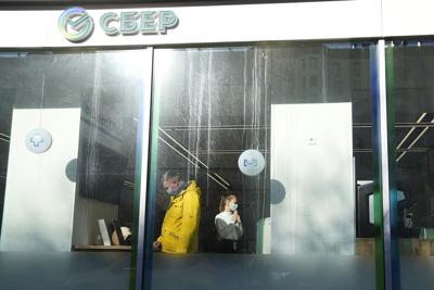 A customer and employee are seen March 2 in a Moscow office of Sberbank, one of the sanctioned Russian entitites.