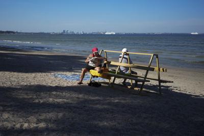 A woman reads a newspaper at the Pirita Beach on the Baltic Sea in Tallinn, Estonia, on Aug. 5, 2022.