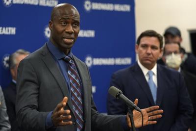 Florida Surgeon General  Joseph A. Ladapo, left, speaks at a Jan. 3 news conference with Florida Gov. Ron DeSantis in Fort Lauderdale.