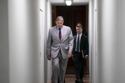 Sen. Joe Manchin, D-W.Va., crosses through a construction tunnel at the Capitol in Washington, Tuesday, June 14, 2022.