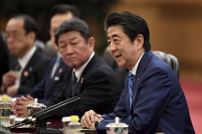 Japan's Prime Minister Shinzo Abe talks to China's President Xi Jinping during a meeting at the Great Hall of the People in Beijing on Dec. 23, 2019.