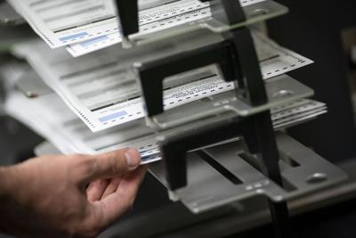 Poll workers sort out early and absentee ballots at the Kenosha Municipal building in Kenosha, Wis.