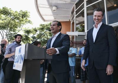 Then-Lt. Gov. Gavin Newsom, right, reacts to former Los Angeles Mayor Antonio Villaraigosa, center, during a news conference on June 19, 2018 in downtown Los Angeles.