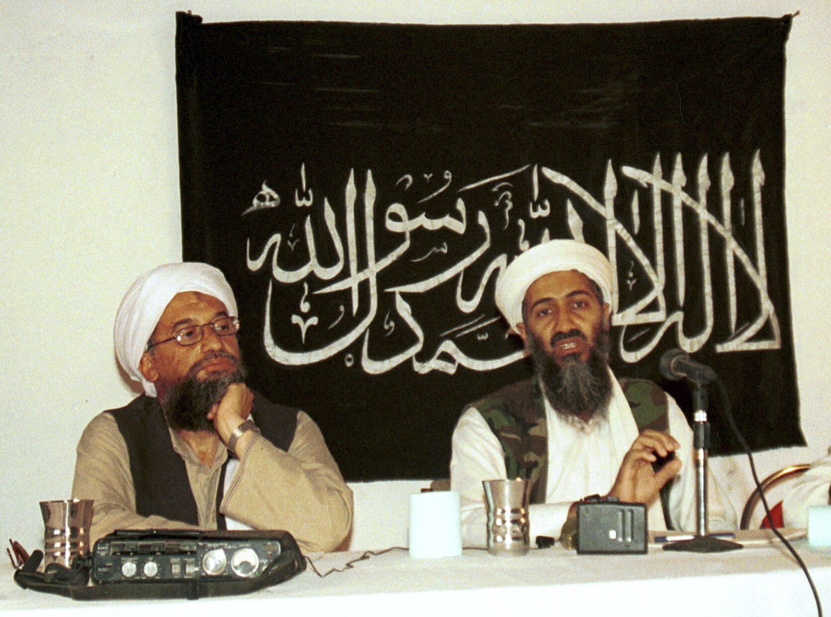 In this 1998 file photo made available Friday, March 19, 2004, Ayman al-Zawahri, left, listens during a news conference with Osama bin Laden in Khost, Afghanistan.