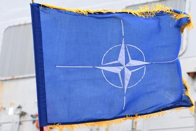 PLYMOUTH, ENGLAND - MARCH 15: A service man poses for the media with a NATO flag at the Devonport Naval Base on March 15, 2019 in Plymouth, England. Two NATO Maritime Groups have arrived in the UK ahead of the large-scale tri-service Exercise 'Joint War...