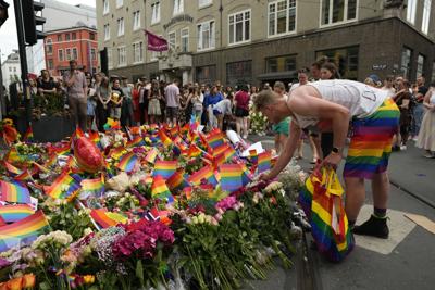 People lay flowers at the scene of a shooting in central Oslo, Norway, Saturday, June 25, 2022.