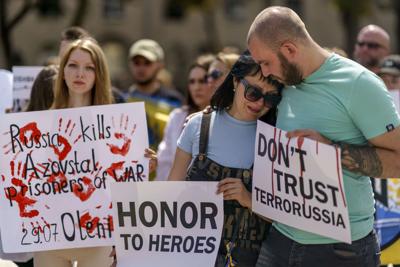 Irina Pidluzhna, the mother of a Ukrainian soldier who was captured by Russia in May, is comforted by Bogdan Sirchenko during a rally in Kyiv on July 30, 2022.