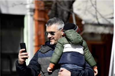 Man on Phone holding child