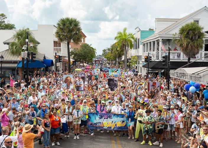 Fans of the late Jimmy Buffett parade along Duval Street in Key West, Fla., during the 2025 "Just a Few Friends" festival celebrating the famed singer-songwriter's life and legacy. The third annual festival is scheduled Sept. 3-7, 2026, on the island Bu...