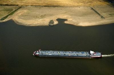 A vessel sails past receding riverbeds on the Rhine near Duesseldorf, western Germany, on Thursday