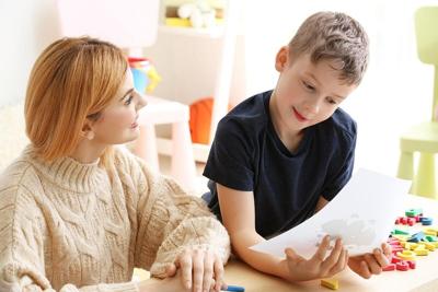 Psicóloga que trabaja con un niño que padece trastorno autista