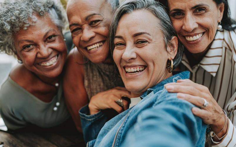 Adult women aged 55 and better smile and share companionship.