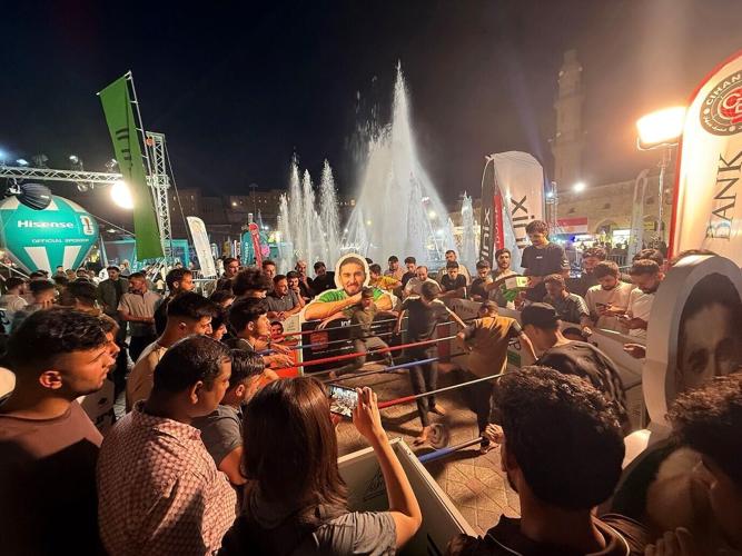 Football fans gather around football challenges at an Infinix World Cup community event in Iraq.