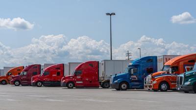 line of semi trucks in parking lot