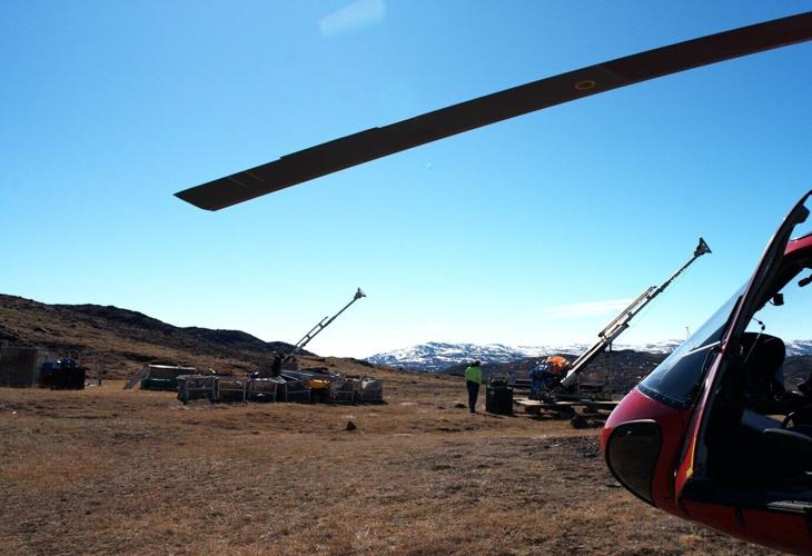 Drill rigs and logistics at Sarfartoq: View across the ST1 plateau showing the  two stored diamond drill rigs, field equipment and the Air Greenland helicopter used during the May 28, 2026 site visit, illustrating the quality of existing drilling and lo...